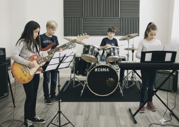 Niños tocando instrumentos en un combo en un aula de la escuela de música Sol Menor