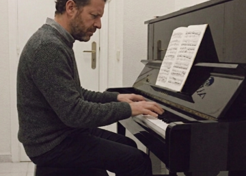 adulto aprendiendo a tocar el piano en una clase de música